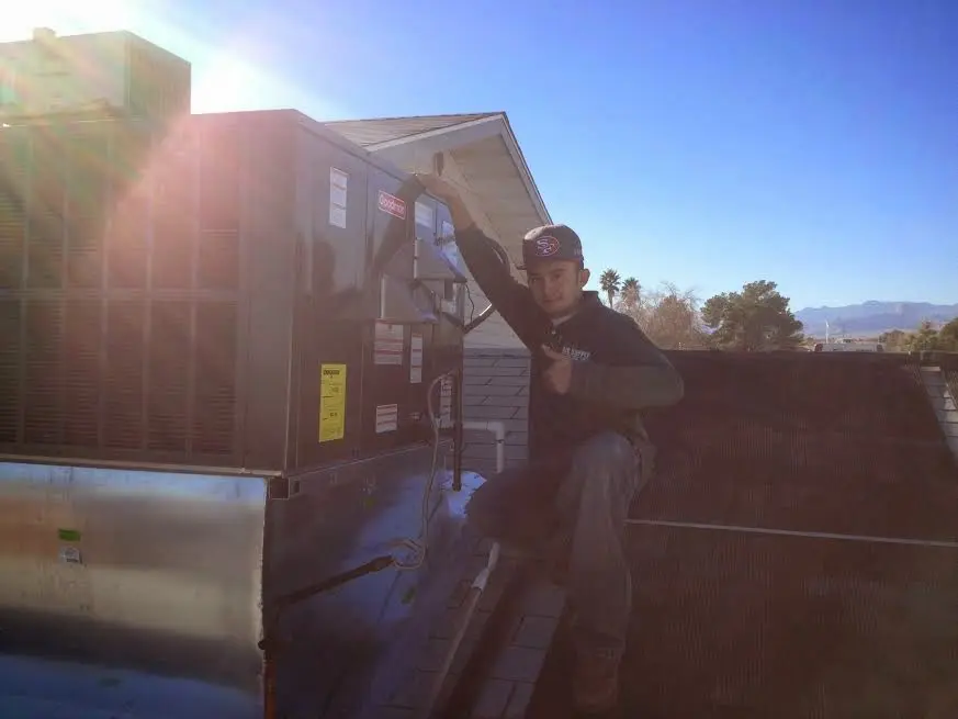 HVAC technician performing AC Tune-Up on a rooftop unit in Slaton